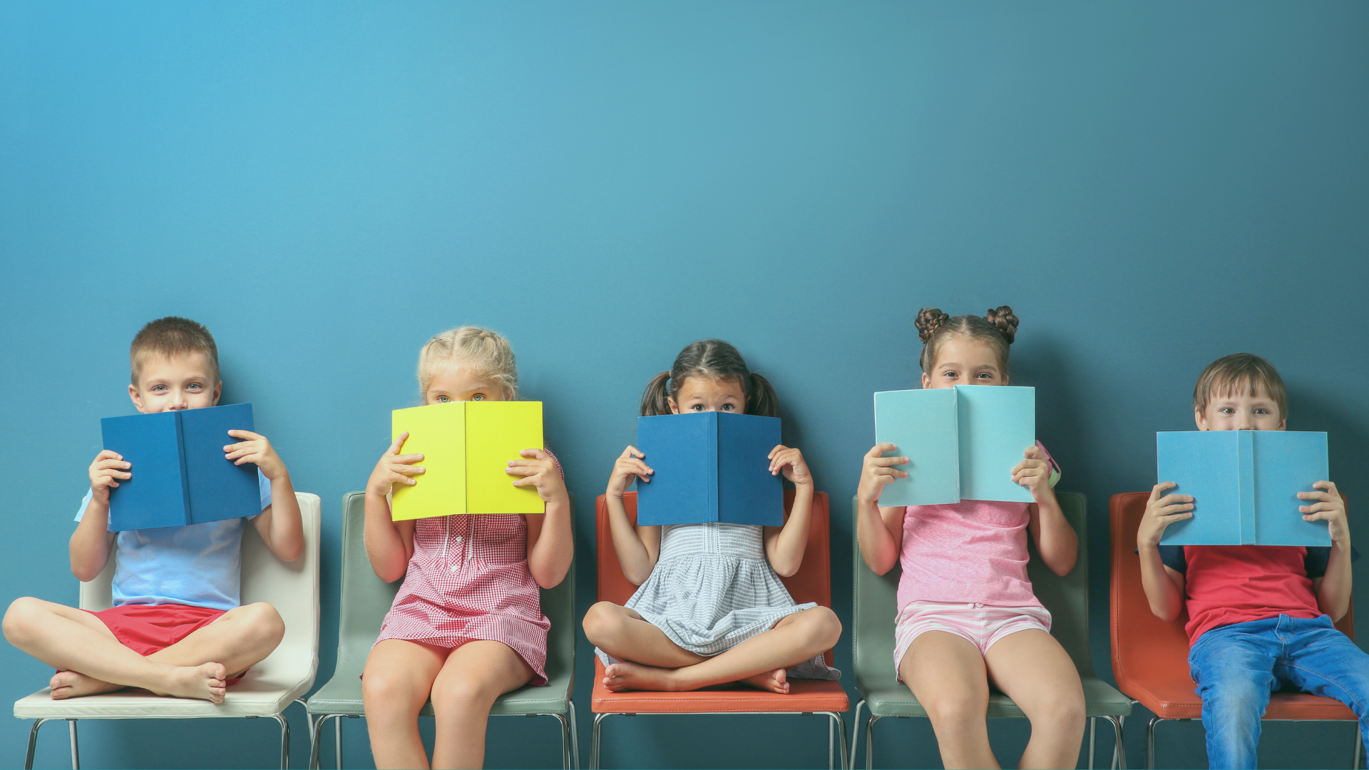 Crianças cobrindo o rosto com livros