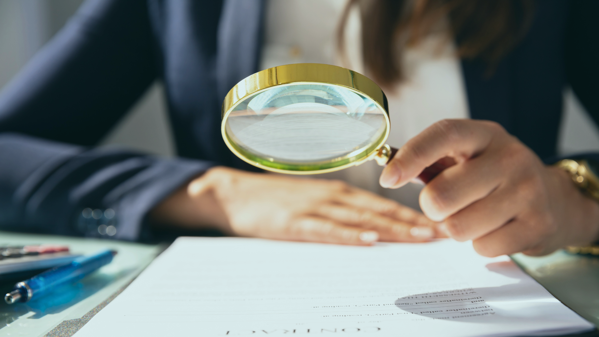 Mulher segurando lupa acima de documento